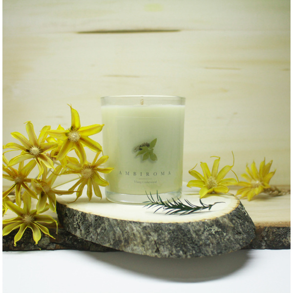 Ylang Cedarwood candle with ylang flowers on wooden board